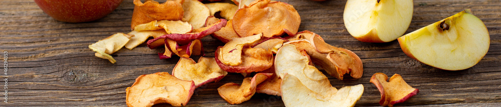 banner of A pile of dried slices of apples and fresh ripe apples on wooden background. banner of A pile of dried slices of apples and fresh ripe apples on wooden background.