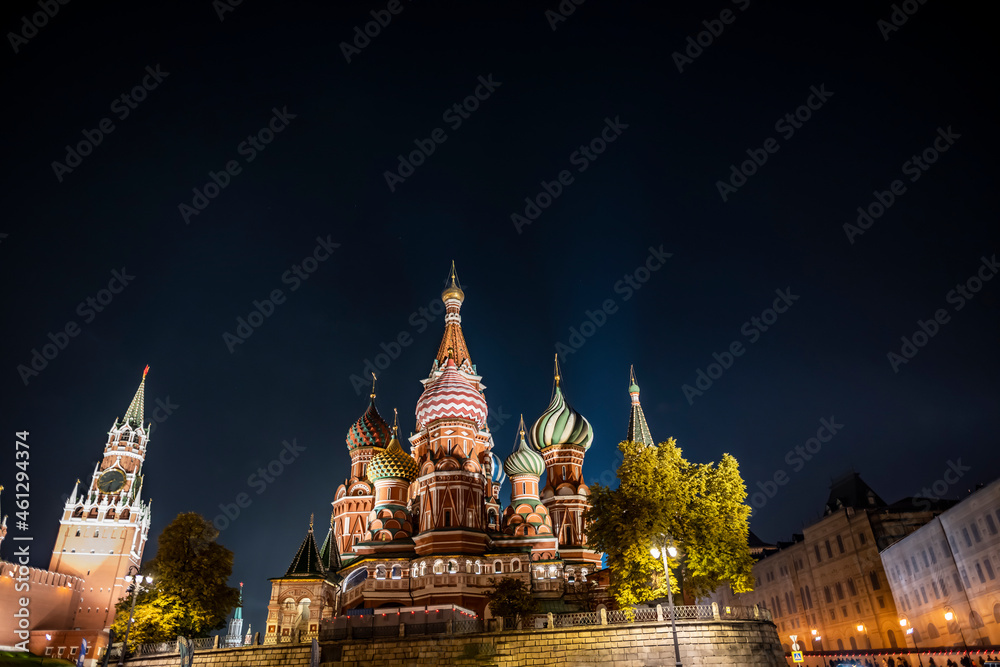 night landscape of the city with illuminated old houses, churches and a fortress wall 