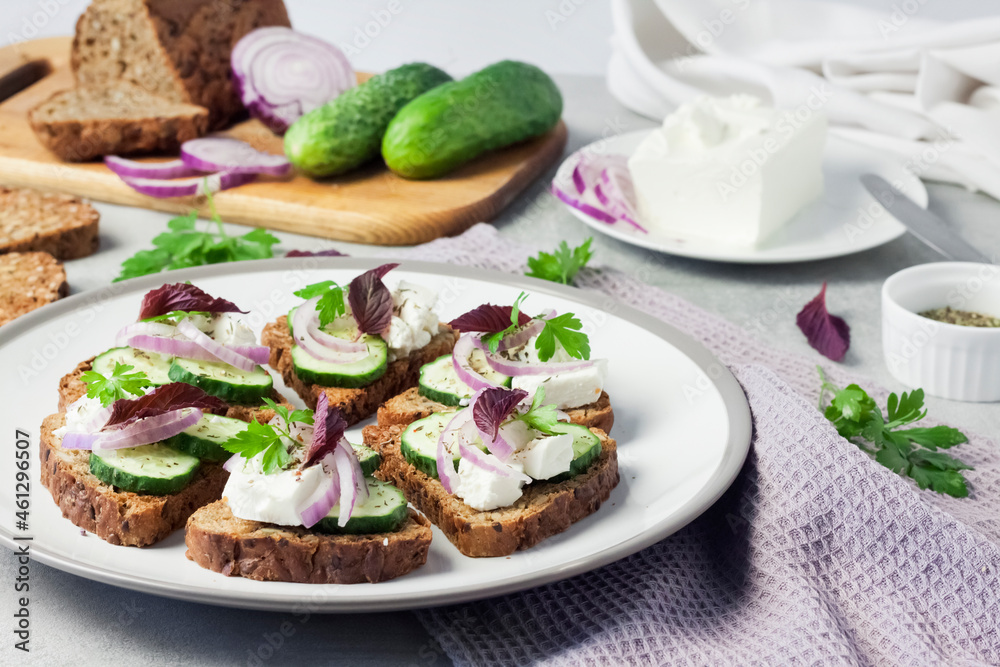 Canapes with toasted bread with sunflower and flax seeds, feta cheese, cucumber and onion Canapes with toasted bread with sunflower and flax seeds, feta cheese, cucumber and onion