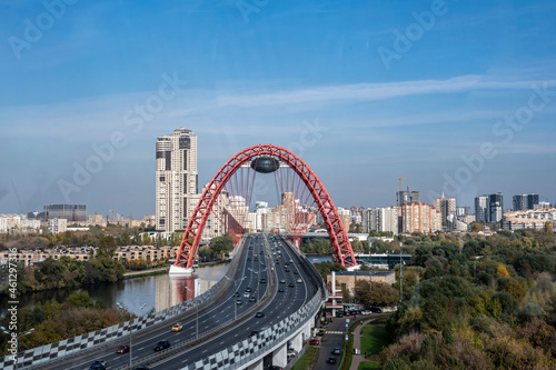 cityscape with red bridge over the river against the blue sky on a sunny day  © константин константи