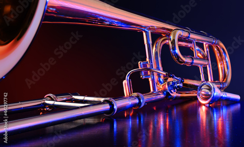 Jazz trombone illuminated with colored lights on black table