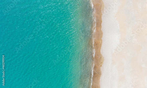 Empty white sand beach and calm turquise sea. Aerial view directly above, background with copy space