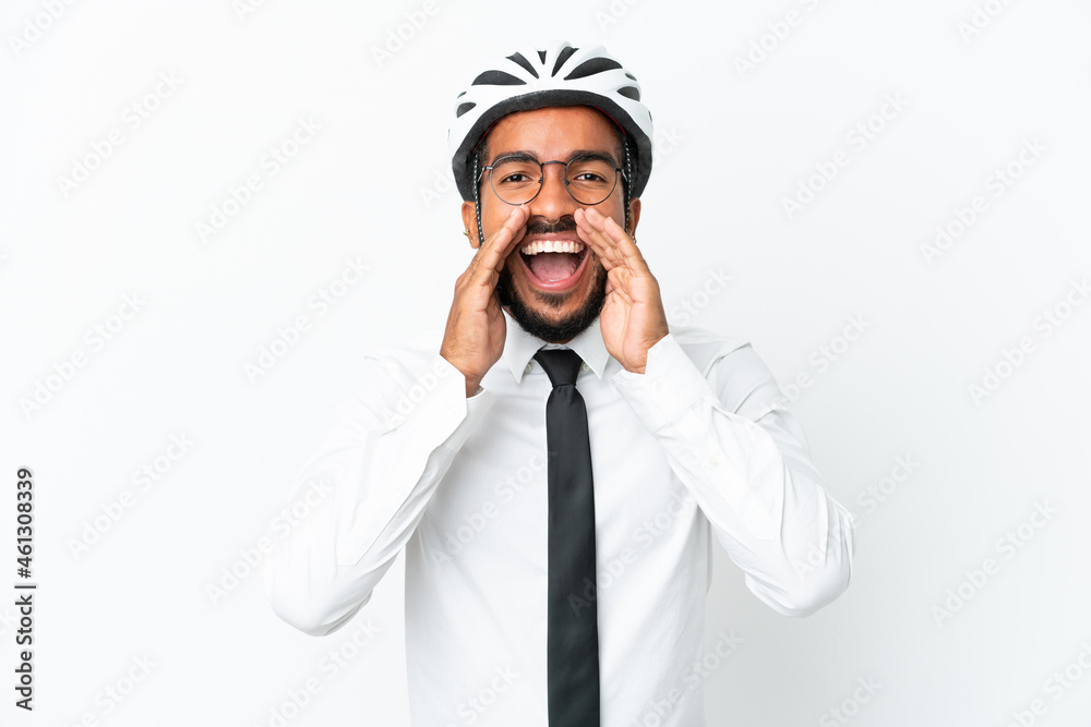 Young business latin man holding a bike helmet isolated on white background shouting and announcing something Young business latin man holding a bike helmet isolated on white background shouting and announcing something