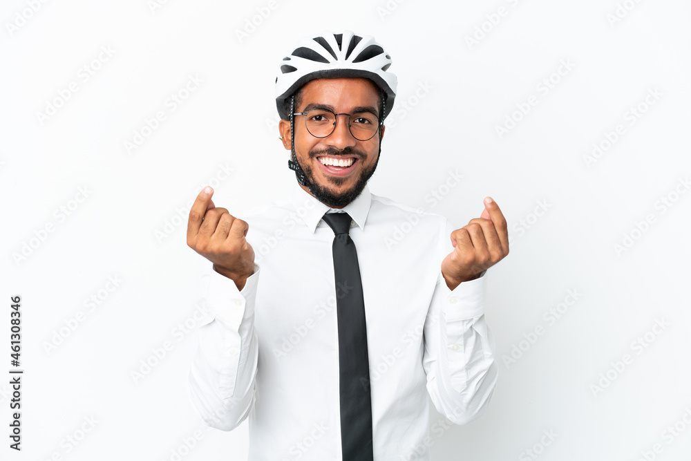 Young business latin man holding a bike helmet isolated on white background making money gesture Young business latin man holding a bike helmet isolated on white background making money gesture