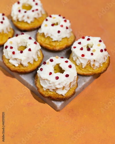 Homemade keto dessert donuts made from almond flour glazed with whipped cream. Gluten-free, low-carb baked goods.