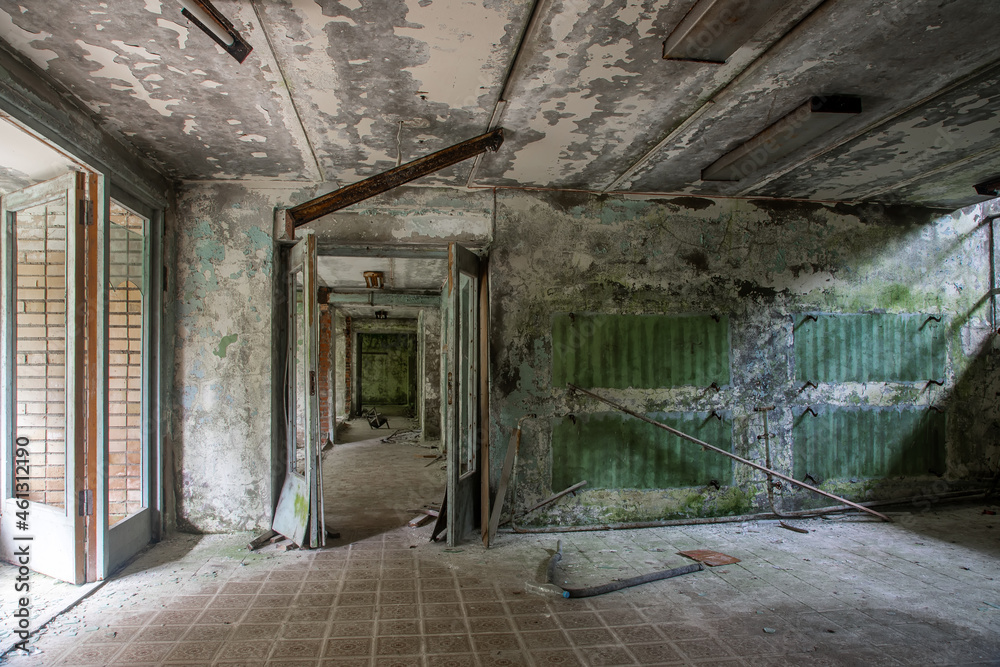 Obraz premium A scary room with a staircase in an abandoned building. Dirty and shabby walls. Stairs with steps. An empty forgotten place. Corridor with a window.