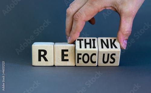 Refocus and rethink symbol. Businessman turns cubes and changes the word 'refocus' to 'rethink'. Beautiful grey table, grey background. Business refocus and rethink concept. Copy space.