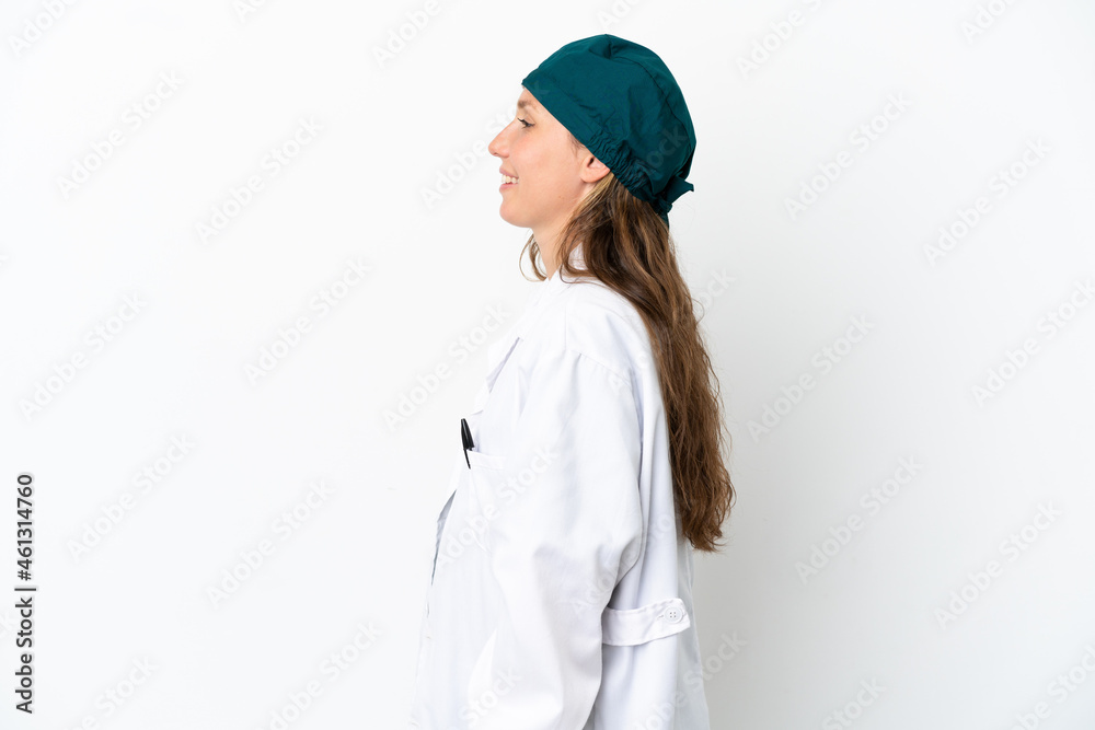 Surgeon caucasian woman in green uniform isolated on white background laughing in lateral position Surgeon caucasian woman in green uniform isolated on white background laughing in lateral position