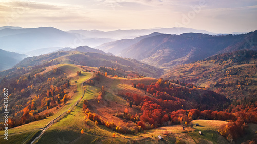 Obraz na płótnie Beautiful mountain autumn landscape with meadow and colorful forest. Red, Yellow, Orange trees on hillsides. w salonie