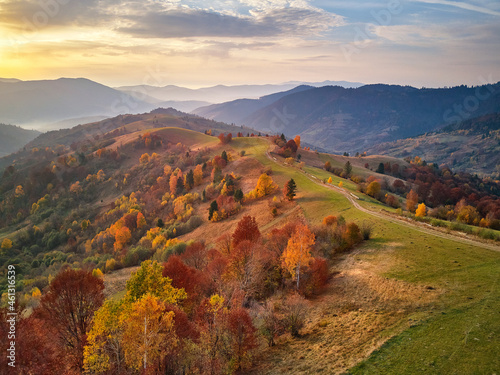Obraz na płótnie Beautiful mountain autumn landscape with meadow and colorful forest. Red, Yellow, Orange trees on hillsides. w salonie