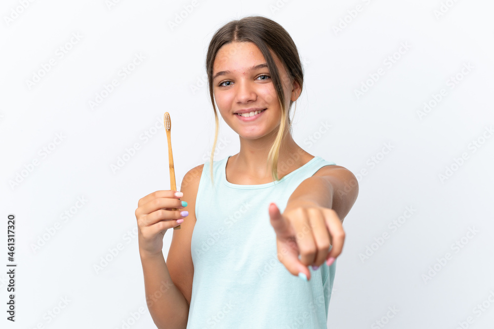 Little caucasian girl holding a toothbrush isolated on white background points finger at you with a confident expression Little caucasian girl holding a toothbrush isolated on white background points finger at you with a confident expression