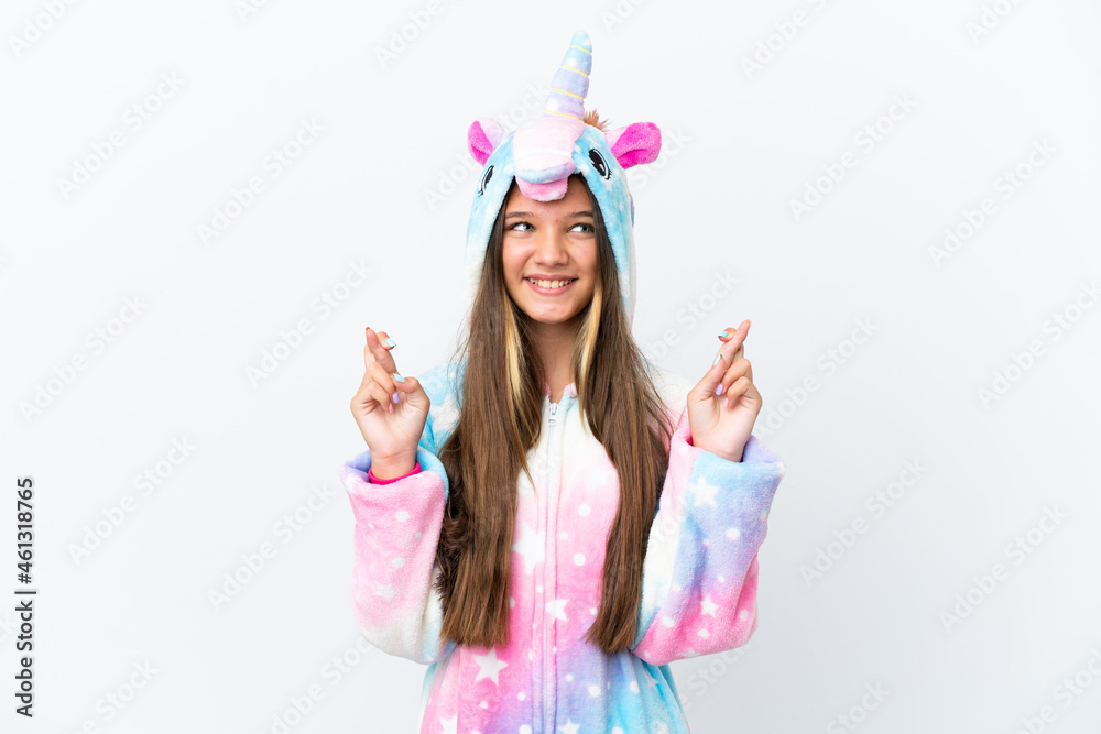 Little caucasian girl wearing unicorn pajama isolated on white background with fingers crossing Little caucasian girl wearing unicorn pajama isolated on white background with fingers crossing
