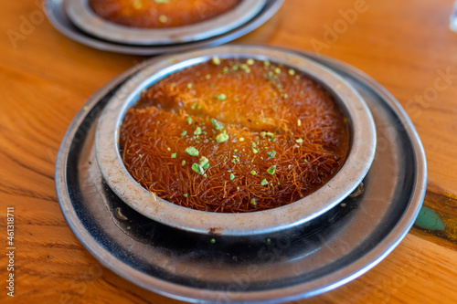 Photography Turkish dessert kunefe, kunafa, kadayif with pistachio powder and cheese, served hot, very sweet