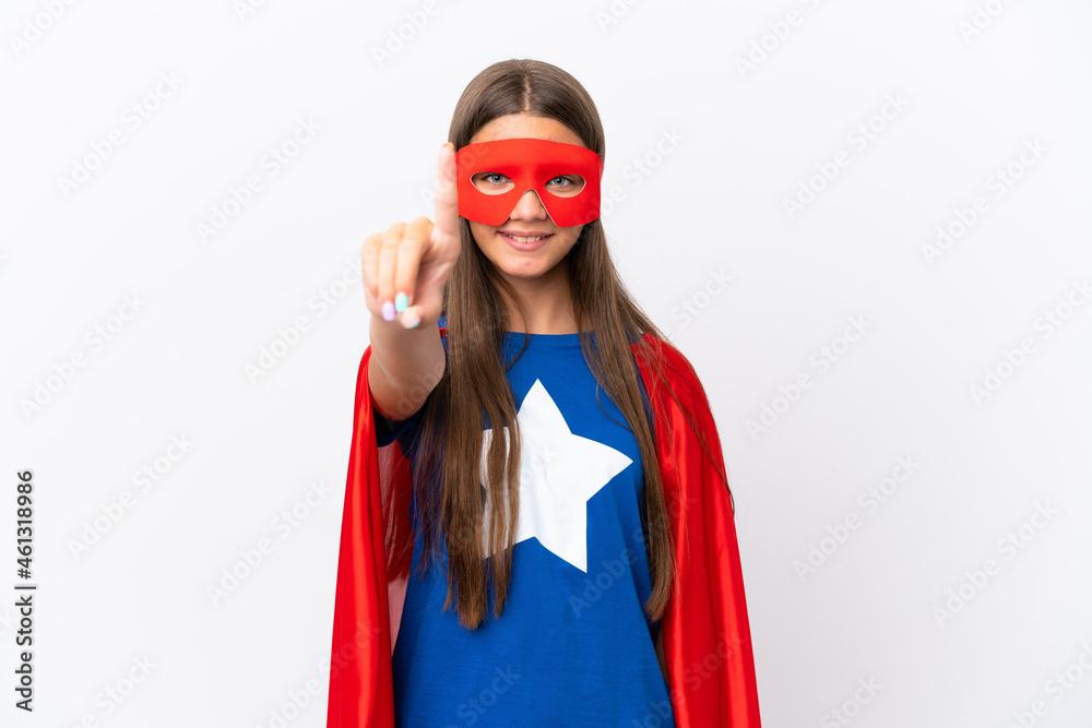 Little caucasian girl isolated on white background in superhero costume and pointing to the front