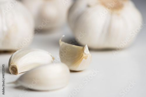 fresh garlic on a white table with garlic gloves
