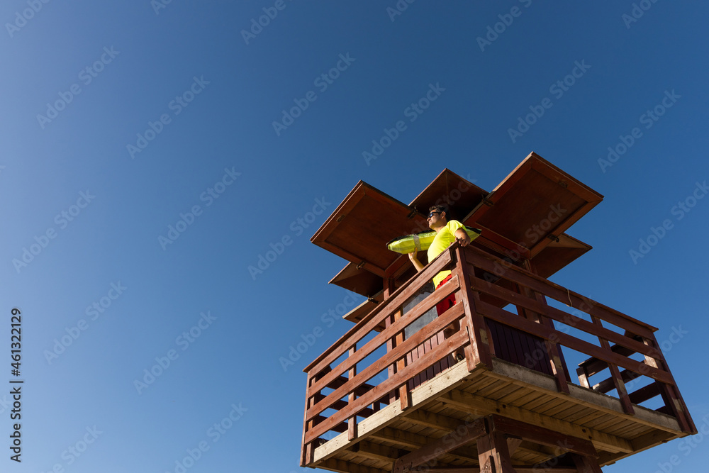 Lifeguard observing on high watchtower on coast Lifeguard observing on high watchtower on coast
