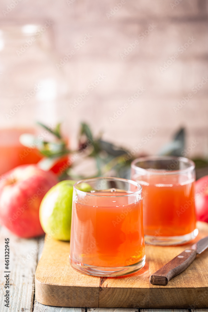 Glass of fresh apple juice and red apples on wooden background Glass of fresh apple juice and red apples on wooden background