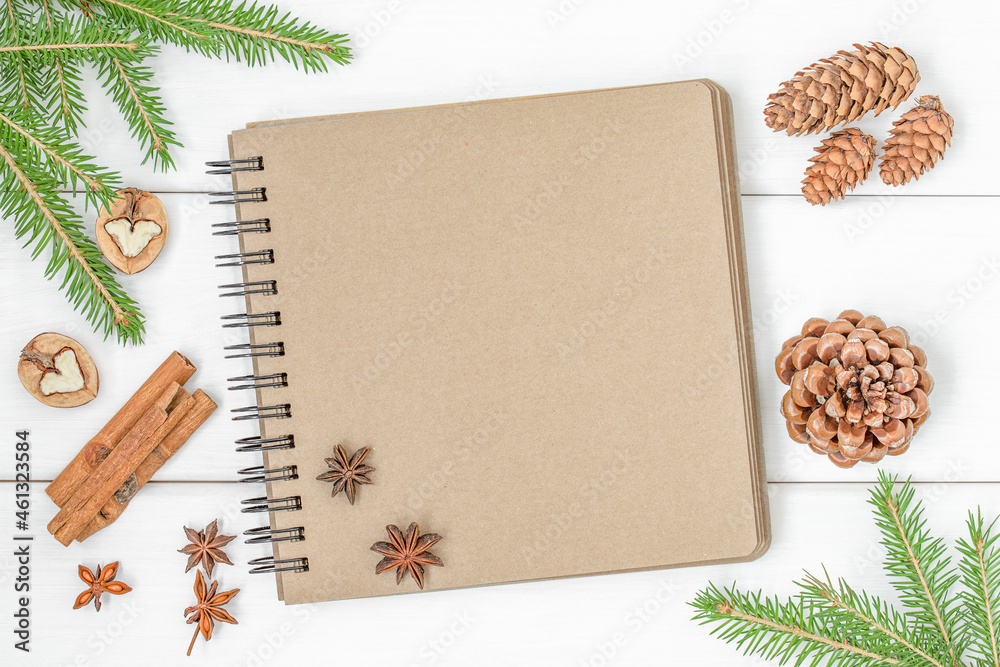 Christmas background with notebook, christmas tree branches, cones and spices on light wooden surface
Christmas background with notebook, christmas tree branches, cones and spices on light wooden surface
