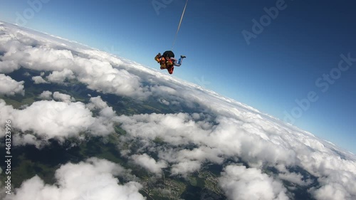 Skydiving. Tandem jump. A young woman and her instructor are flying in the sky.