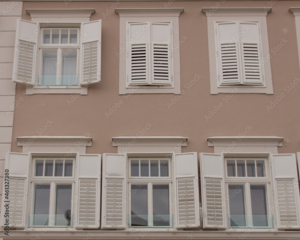 Weiße Fenster mit Fensterläden auf Brauner Mauer