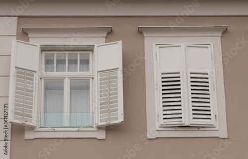 Weiße Fenster mit Fensterläden auf Brauner Mauer