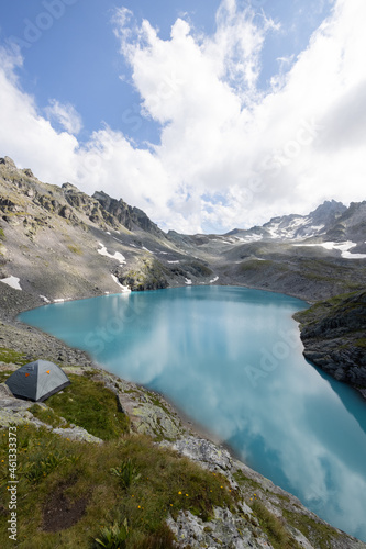 Amazing hiking day in one of the most beautiful area in Switzerland called Pizol in the canton of Saint Gallen. A wonderful view at the alpine lake called Wildsee with a tent by the lake. Epic view. photo