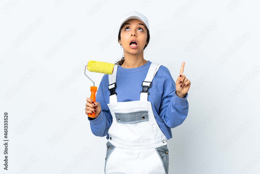 Painter woman over isolated white background surprised and pointing up