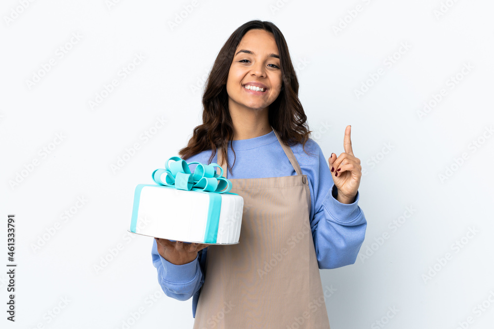 Pastry chef holding a big cake over isolated white background pointing up a great idea Pastry chef holding a big cake over isolated white background pointing up a great idea