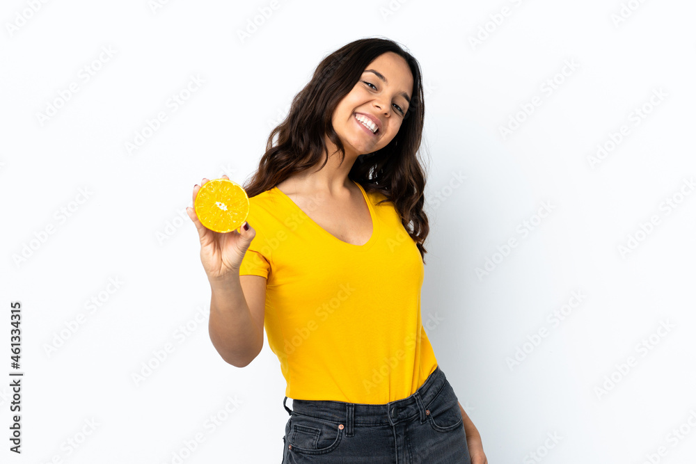 Young woman over isolated white background holding an orange Young woman over isolated white background holding an orange