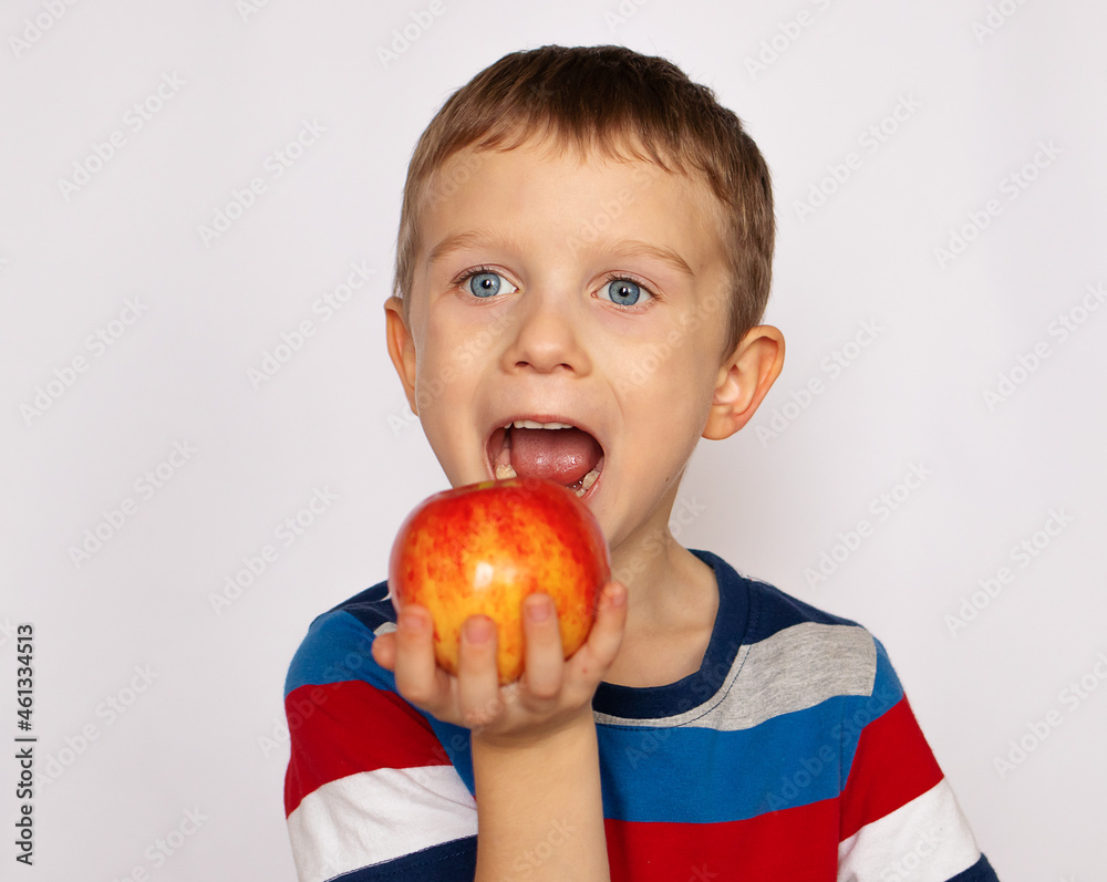 Boy eating a red apple. Health food. Fruits