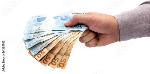 hand on isolated white background offering brazil money, one hundred and fifty reais banknotes, brazilian economy.