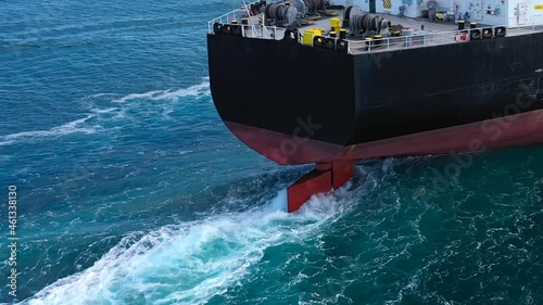 Close up of Large rudder of an oil tanker ship maneuvering into position a long distance off. Aerial following crude oil tanker from behind. Supertanker designed for chemical products transportation
