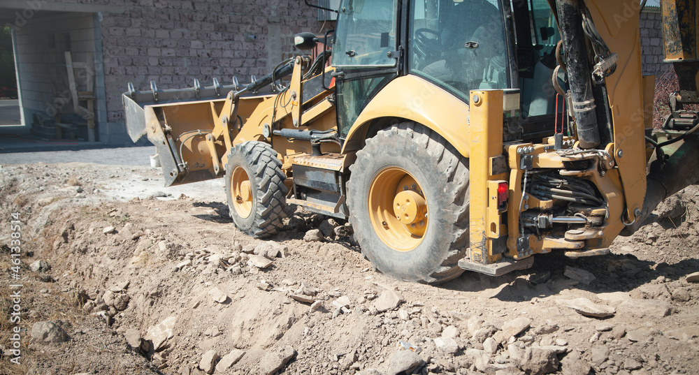 Excavator works at a construction site. Excavator works at a construction site.