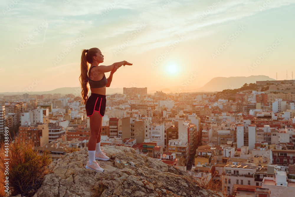 pretty young woman does yoga overlooking the city at sunset outdoors pretty young woman does yoga overlooking the city at sunset outdoors