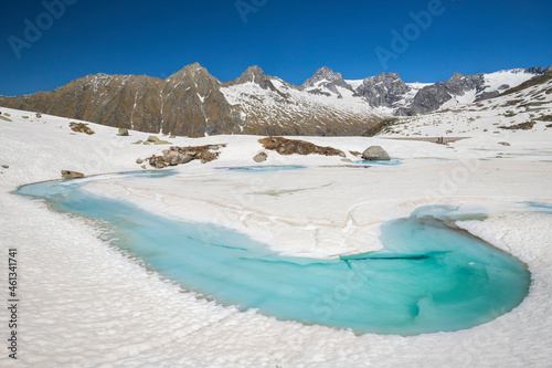 Blue Water of Alpine Lake during Thaw in Spring, Adamello Park, Lombardy, Italy 