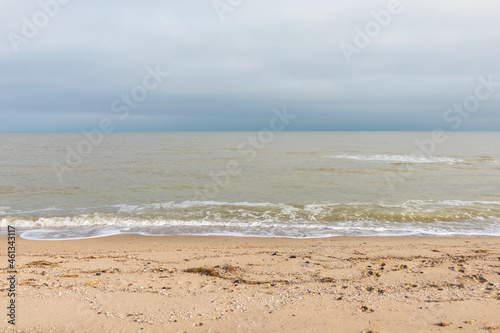 Close up view on calm sea water and sand. Summer vacation. Beach recreation. Ocean theme. Natural background.