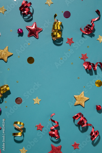 Festive background for winter holidays with color sparkles, stars, confetti, streamers flat lay
