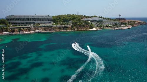 Aerial drone video from famous celebrity sandy beach of Astir or Asteras in south Athens riviera with turquoise clear sea, Vouliagmeni, Greece