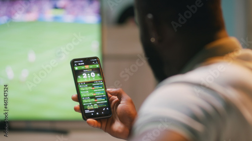 Foto African American fan placing online stakes and speaking