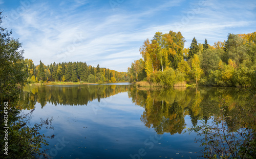 A lake in a forest under a blue sky with clouds