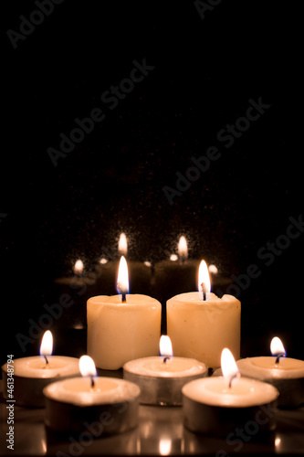 Burning candles on a black background  symbol of religion and loss or tragedy photo