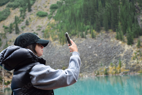 Young girl taking pictures outdoors with mobile phone