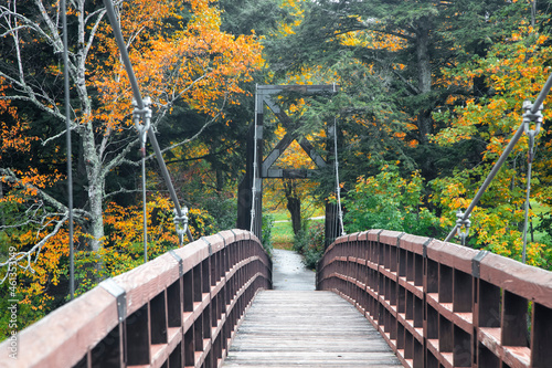 Suspension bridge in Black river county park in Michigan upper peninsula surrounded with colorful fall foliage