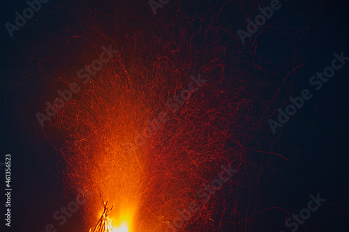 Sparks flying from the fire against the background of the night sky.