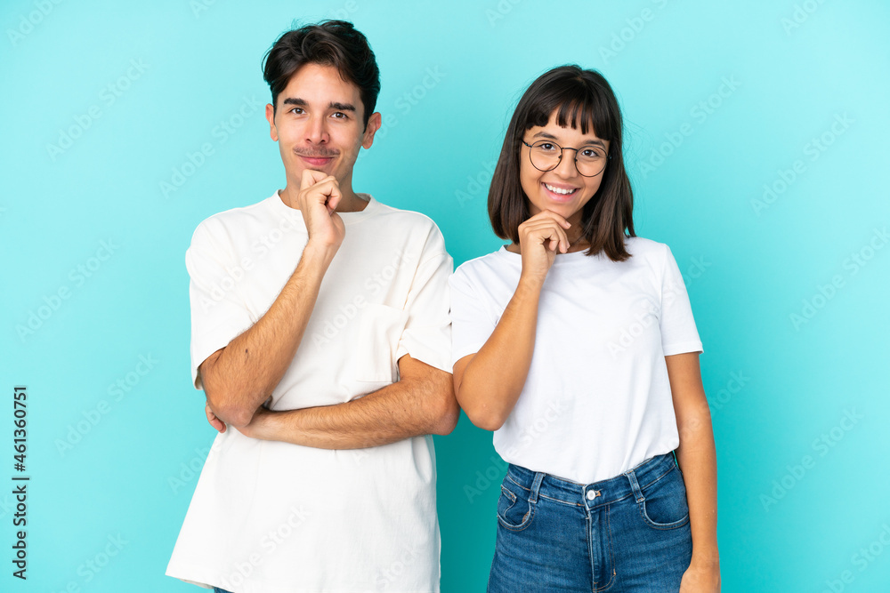 Young mixed race couple isolated on blue background smiling with a sweet expression Young mixed race couple isolated on blue background smiling with a sweet expression