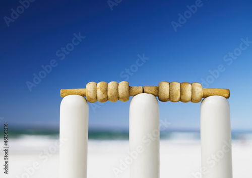 Bails on top of stumps to create a wicket ready to play cricket at the beach photo