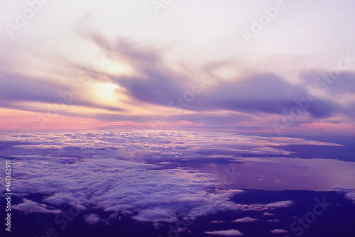 Looking down at top of clouds and sun setting photo