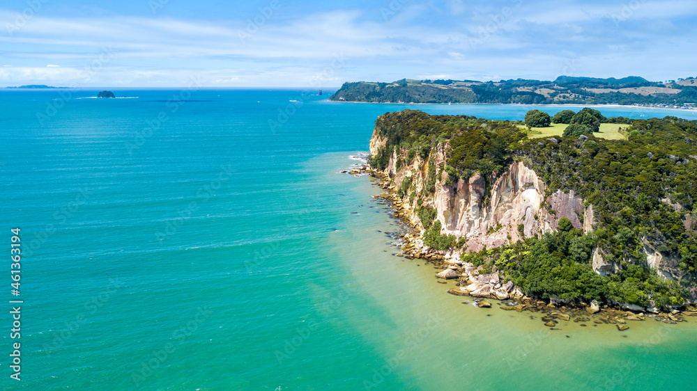 Aerial view on a rocky cliff with a beautiful harbour on the background. Coromandel, New Zealand.