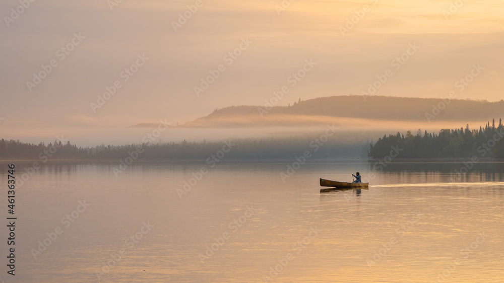 People are boating on Caribou Lake on a fogy morning People are boating on Caribou Lake on a fogy morning