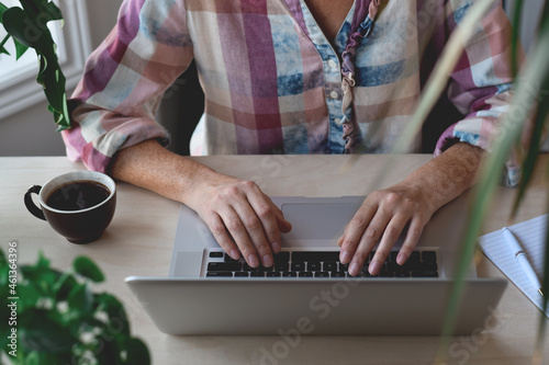 Woman sitting at desk typing on laptop computer